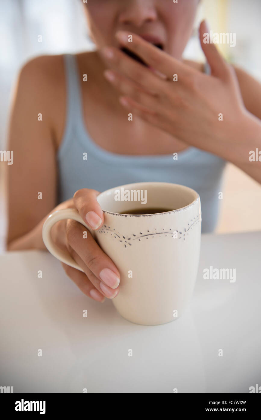 Gähnende Hispanic Frau Kaffee trinken Stockfoto