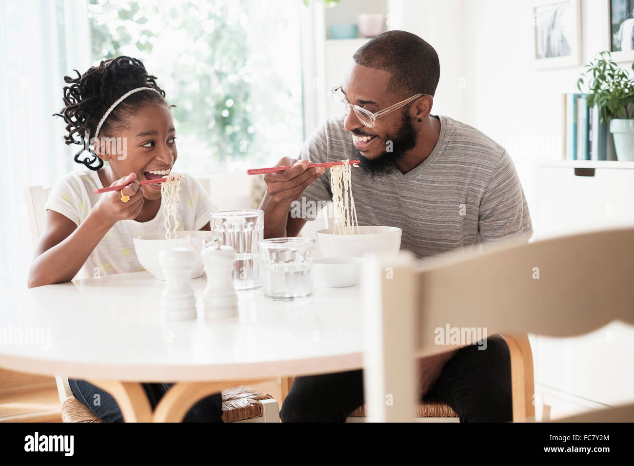 Schwarze Vater und Tochter essen Nudeln Stockfoto