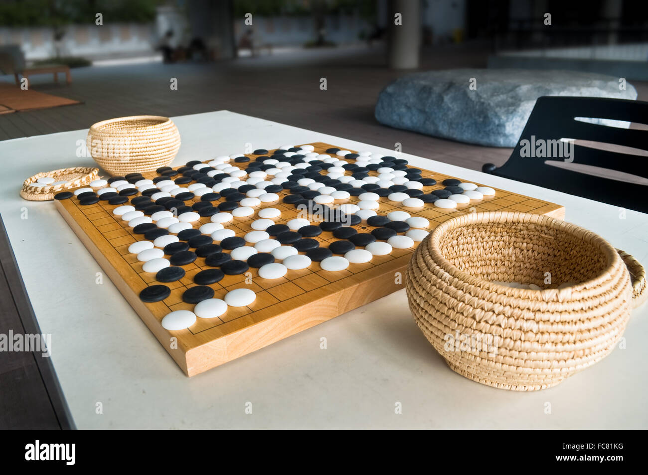Endete Go-Spiel auf Holzbrett mit chinesischen Stil gespielt Stein Stücke, Steinen mit Kurve auf der einen Seite und auf der anderen Seite flach. Stockfoto
