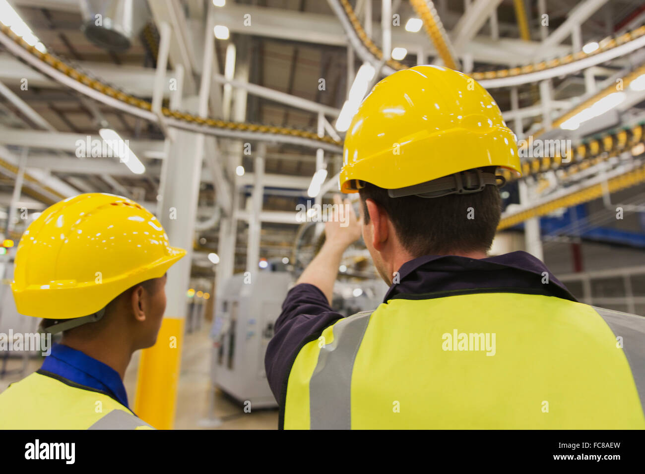 Arbeiter diskutieren drucken drücken Förderbänder overhead Stockfoto