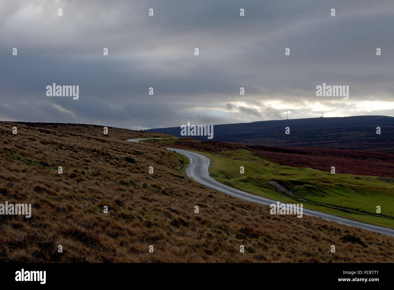 Landschaft Foto von einem isolierten Hügel, kurvenreiche Straße unter bewölktem Himmel. Stockfoto