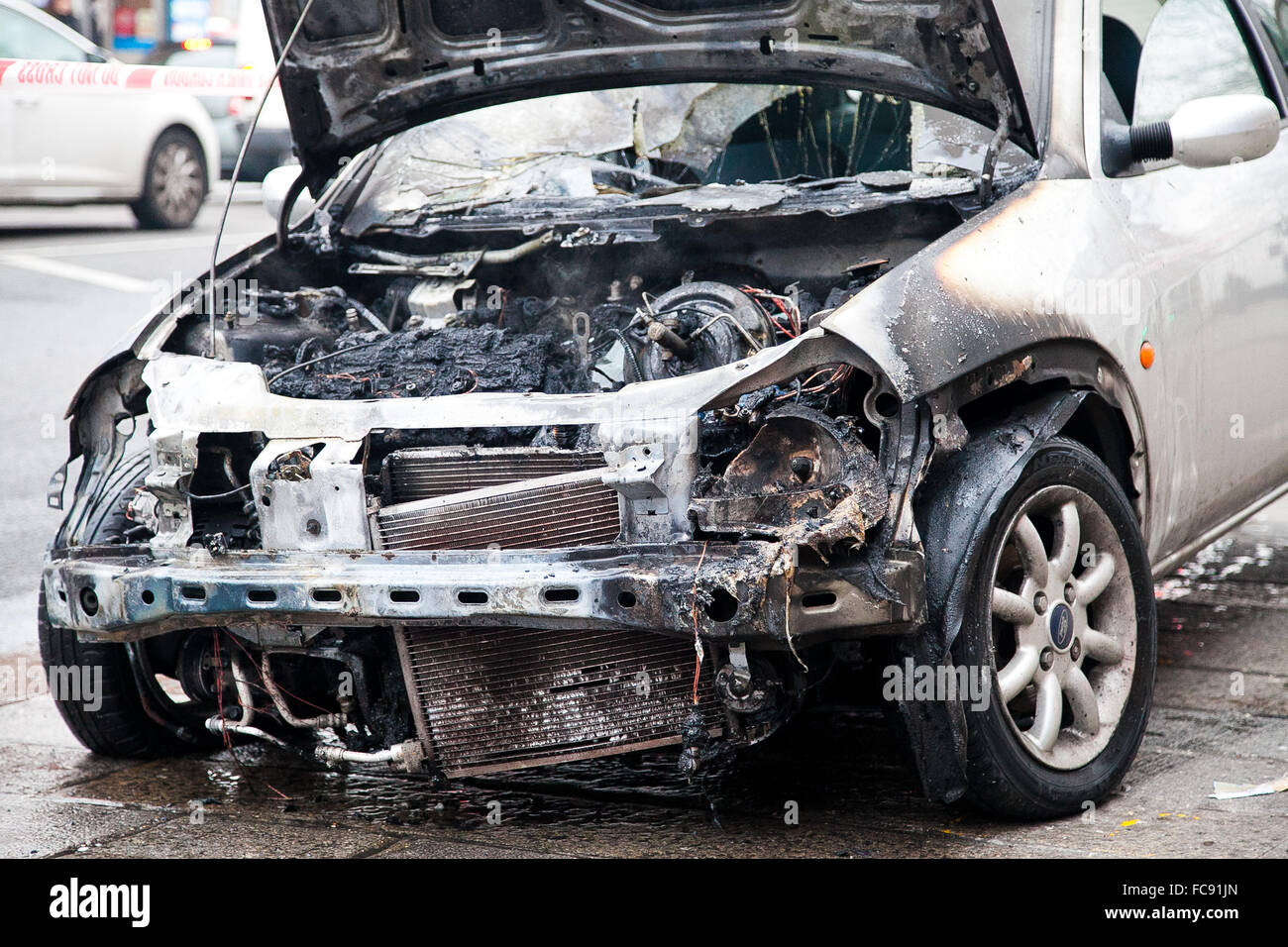 London, UK, 21. Januar 2016. Ein Ford-Auto Feuer fing außerhalb Tesco Express auf Holz grün High Road am frühen Morgen.  Rauch immer noch obwohl der verbrannten Motor und die Schriftart des Autos. Polizei abgesperrt das ausgebrannte Auto mit Polizei Klebeband. Bildnachweis: Dinendra Haria/Alamy Live-Nachrichten Stockfoto