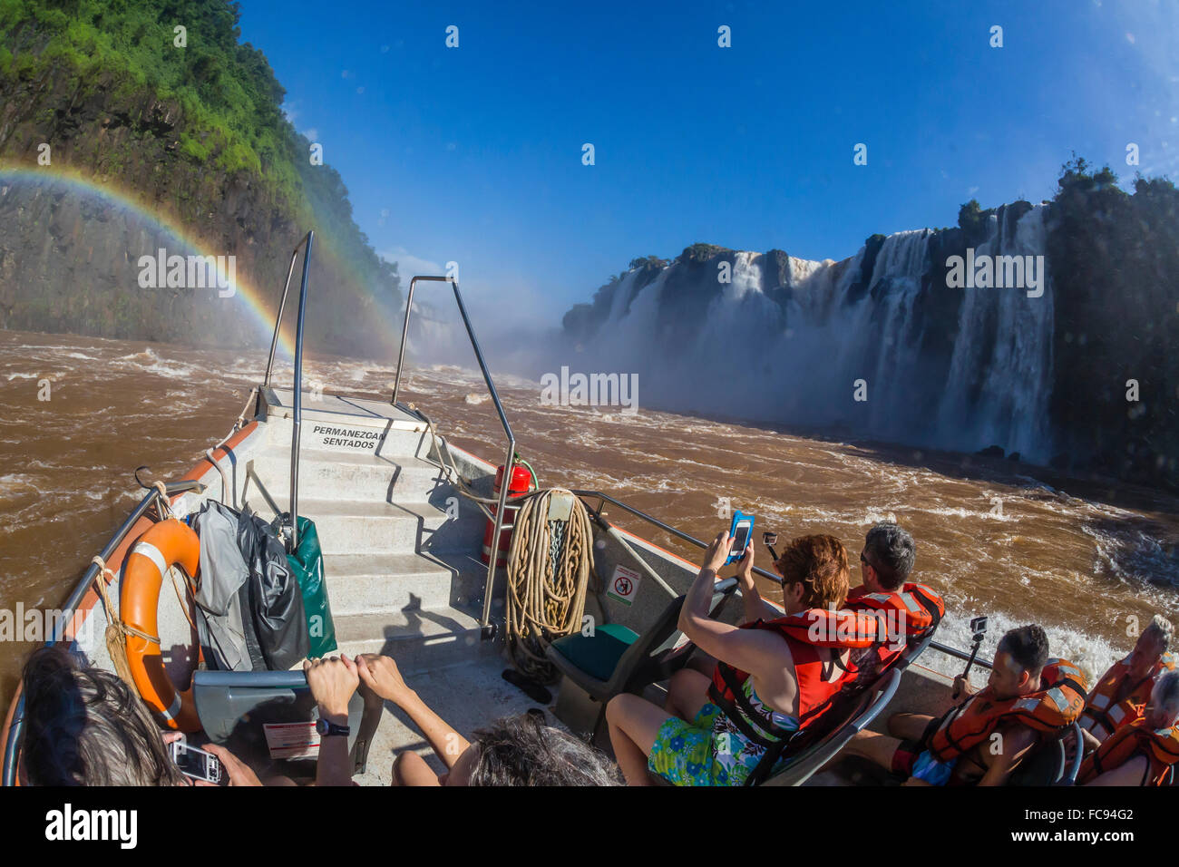 Touristen nehmen eine Bootstour an der Basis des Wasserfalls, Iguazu Falls National Park, UNESCO-Weltkulturerbe, Misiones, Argentinien Stockfoto