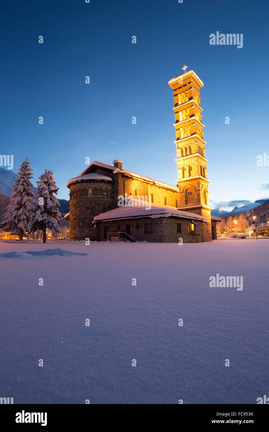 Dämmerung und Lichter auf der Kirche umgeben von Schnee, Sankt Moritz, Engadin, Kanton Graubünden (Graubünden), Schweiz, Europa Stockfoto