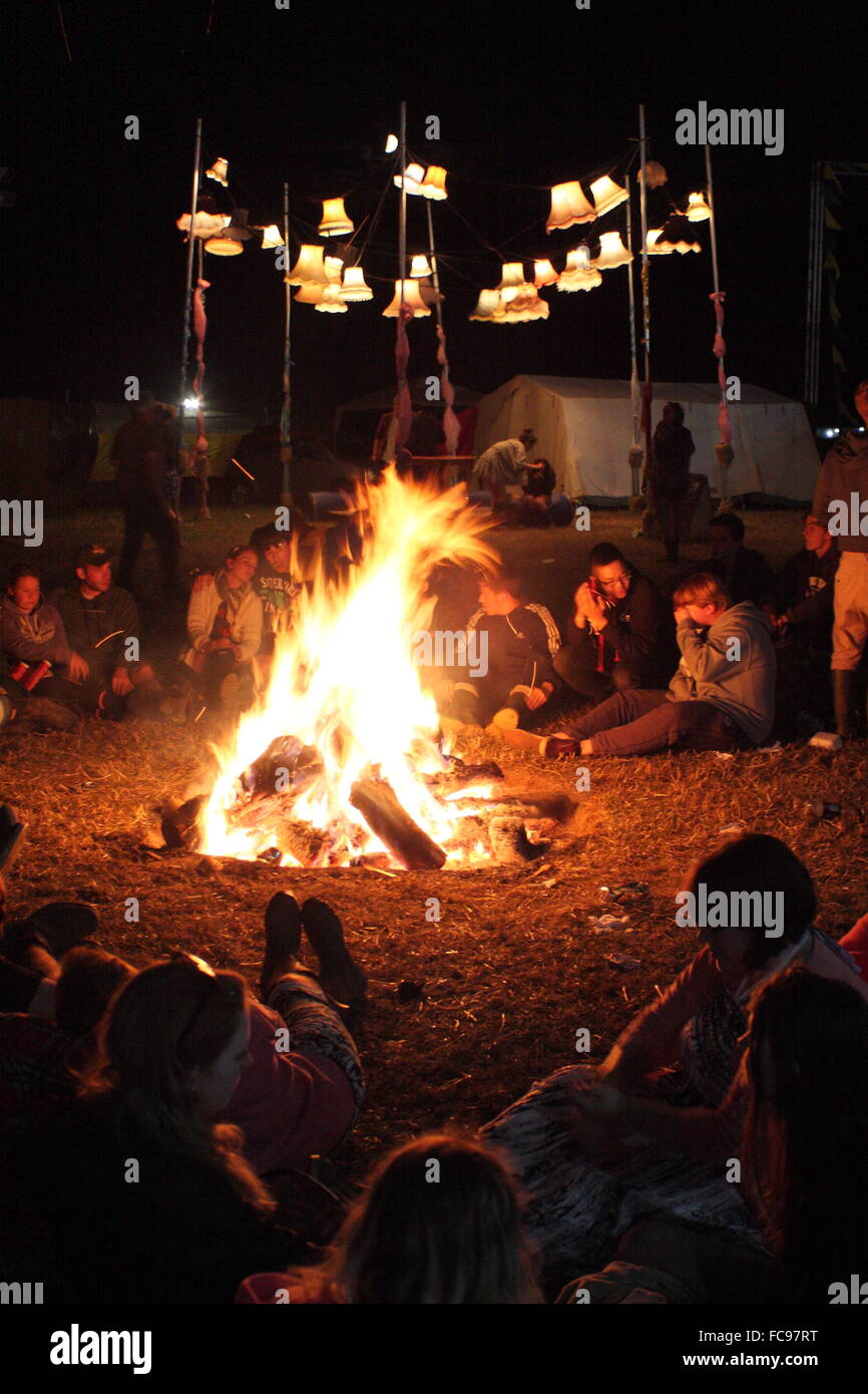 Festivalbesucher sitzen um ein Lagerfeuer auf dem Y Not Music Festival im Peak District Derbyshire England UK - Sommer Stockfoto