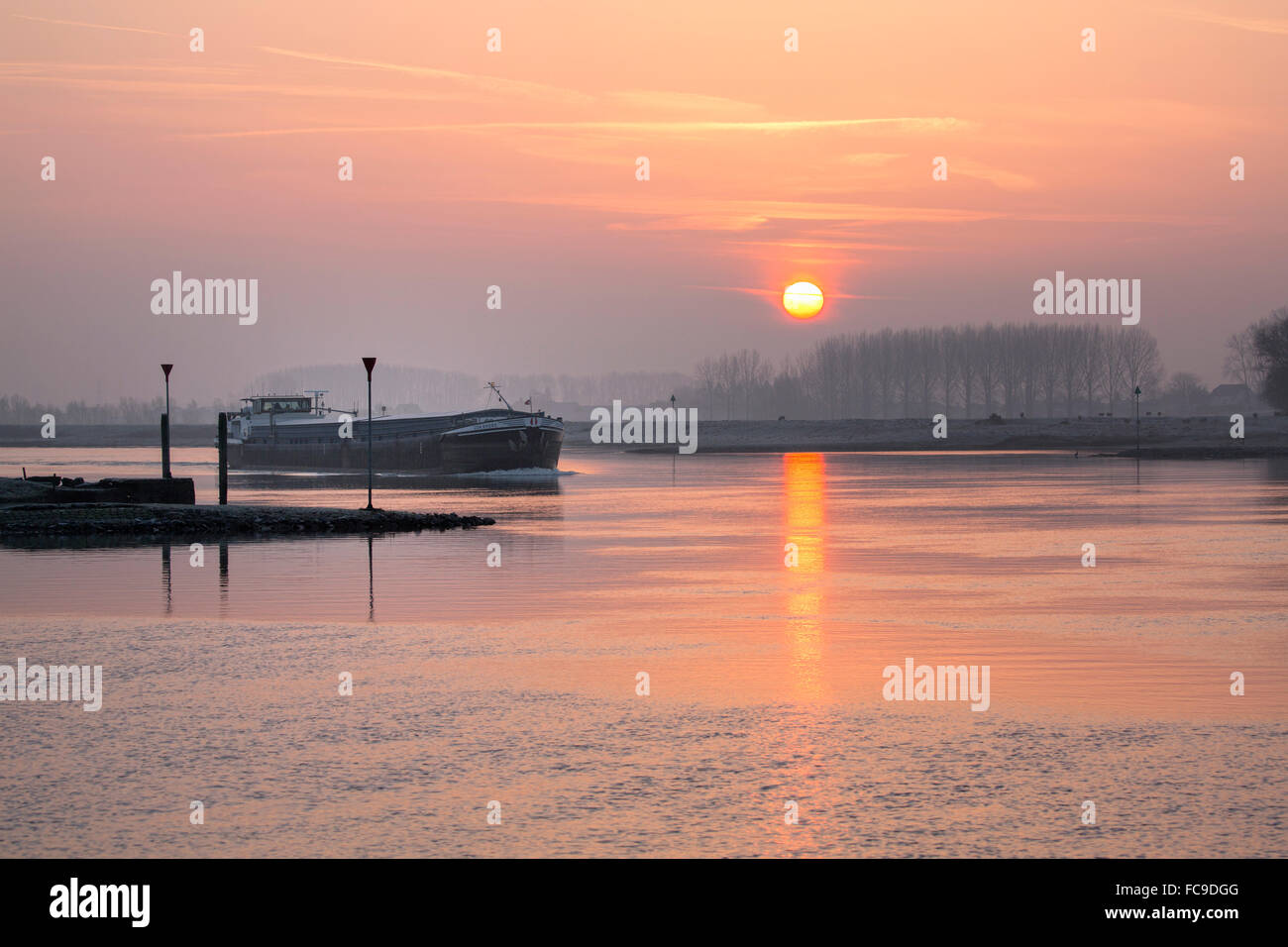 Niederlande, Opheusden, River genannt Nederrijn. Sunrise. Frachtschiff. Stockfoto