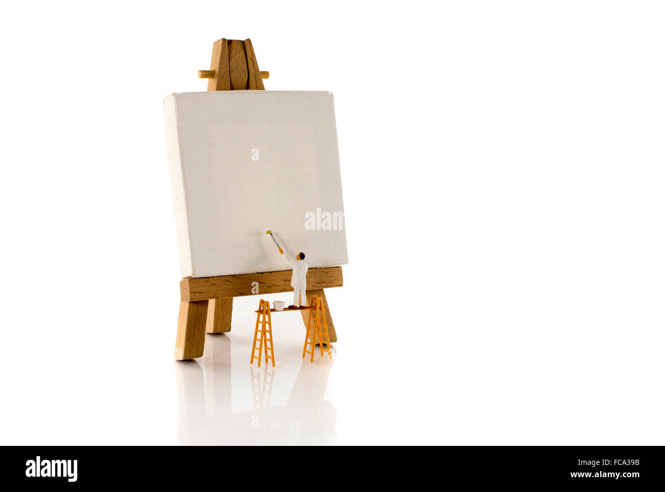 Spielzeug Puppe Mann Maler Malerei Leinwand stehend auf Arbeit und Lack mit der Walze Stockfoto