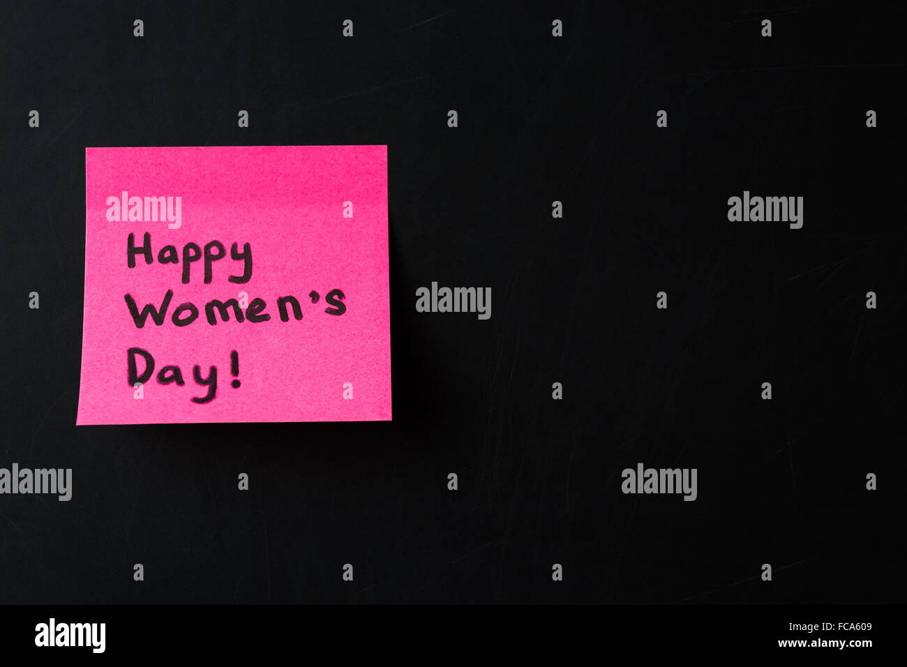 Glückliche Frauen Tag. Rosa Aufkleber auf schwarzen Tafel, 8. März. Selektiven Fokus Stockfoto