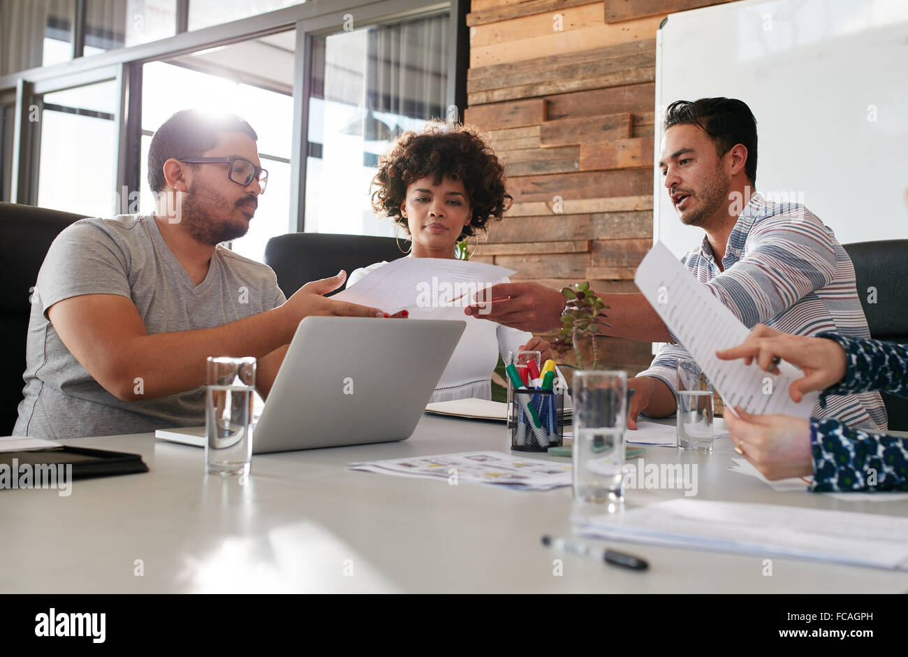 Porträt der jungen Büroangestellten treffen in einem Sitzungssaal. Team von Rassen Menschen arbeiten im Tagungsraum diskutieren. Menschen geben Stockfoto