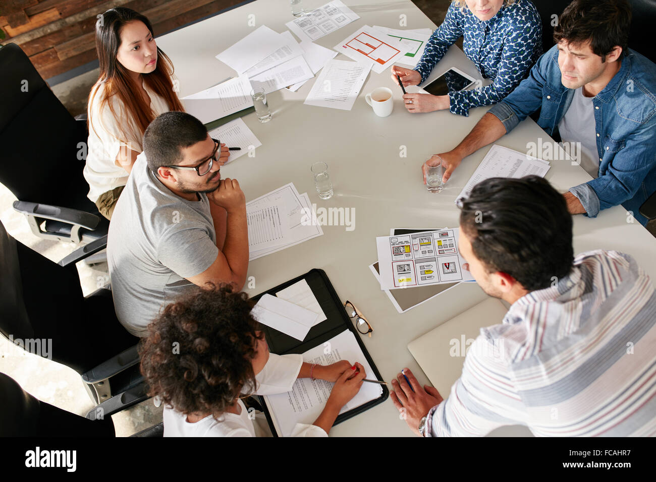 Erhöhte Ansicht des Kreativteams an Tisch Geschäftsideen diskutieren. Gemischte Rassen Team von Kreativ-Profis Teepausen Stockfoto