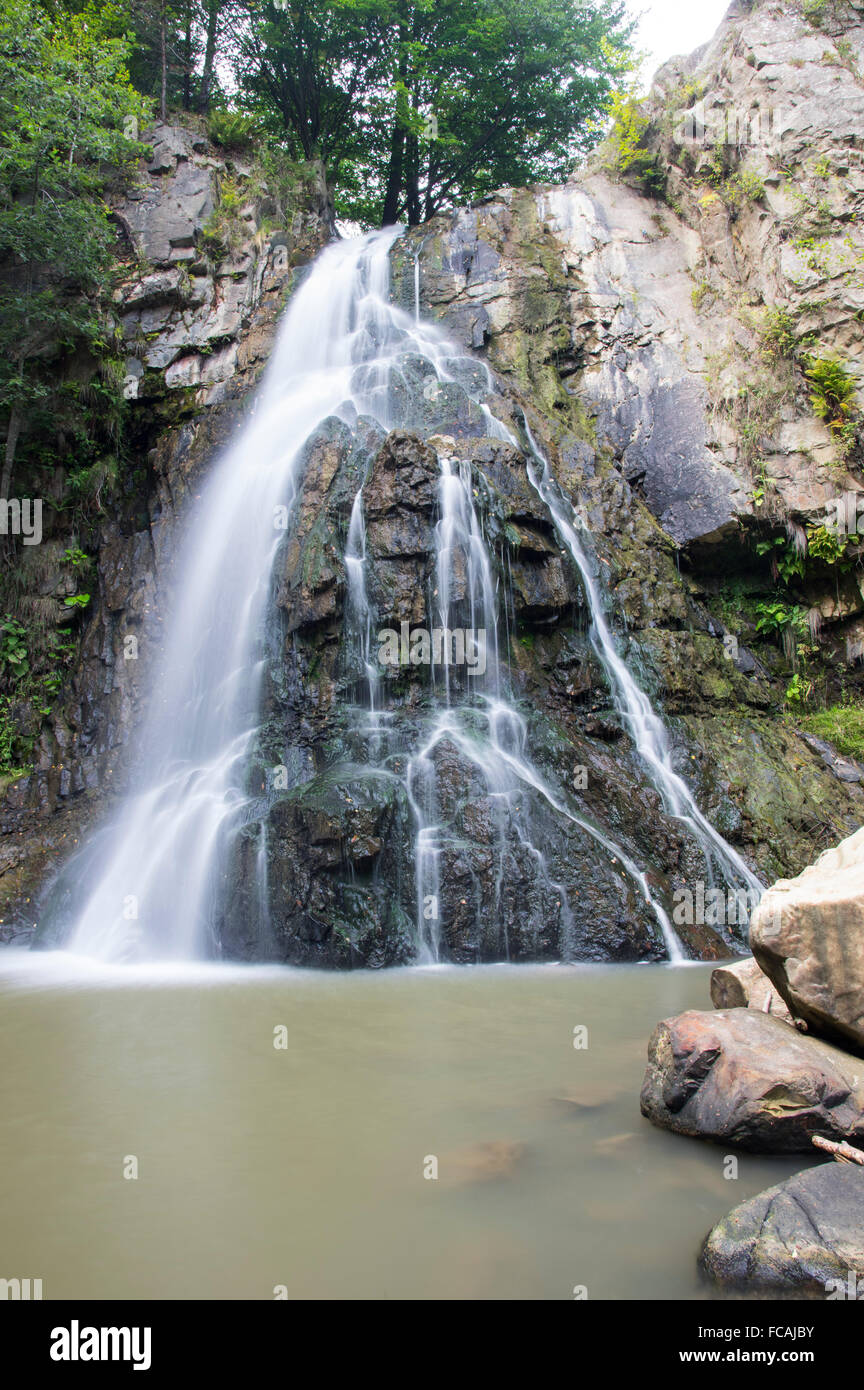 Wasserfall kommt aus einem riesigen Felsen, Bucias Wasserfall in rumänischen Ostkarpaten. Stockfoto