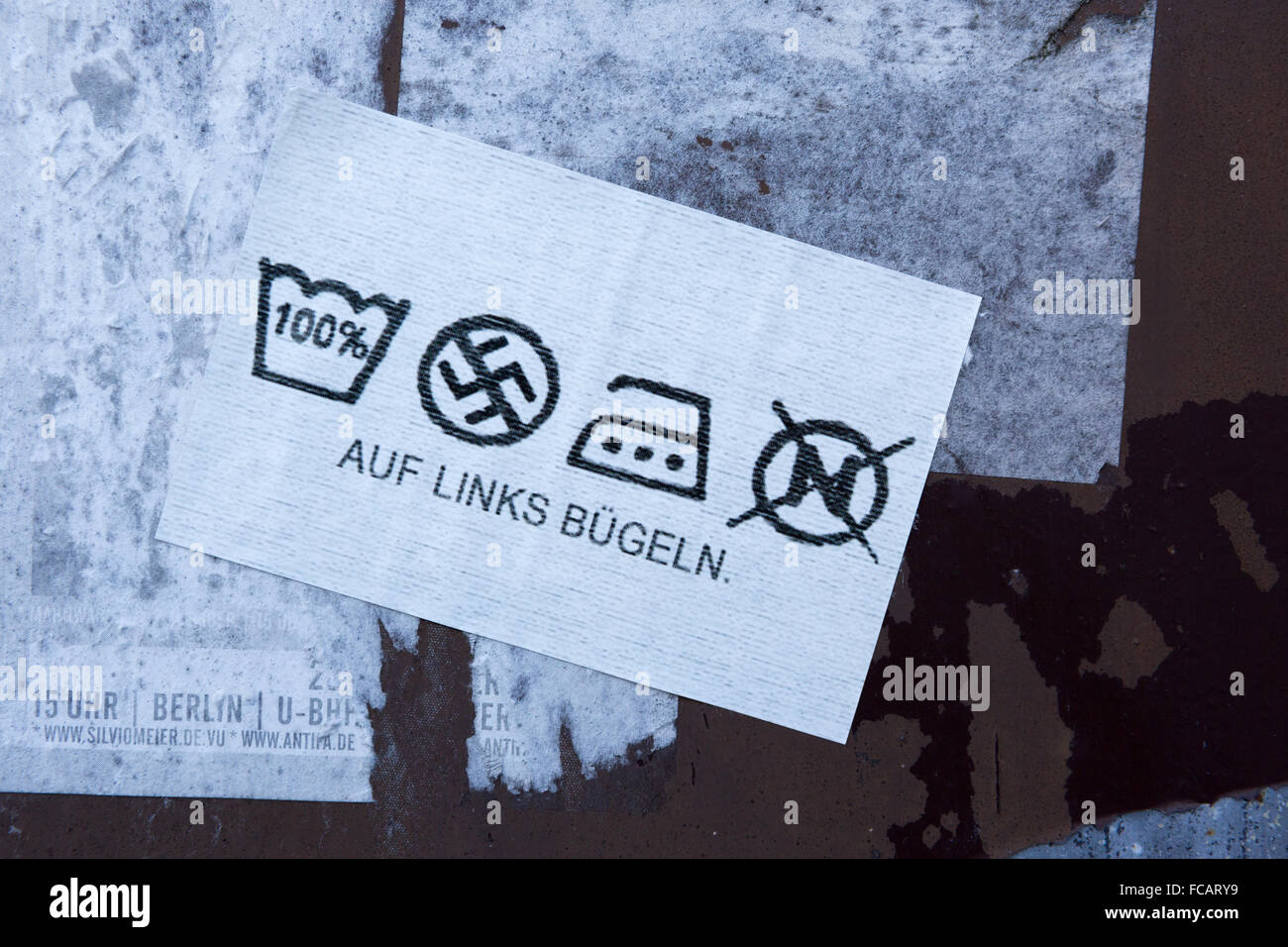 Ein Anti-Nazi-Aufkleber an der Wand in Deutschland im Stil einer Waschanleitung Kleidung label Stockfoto