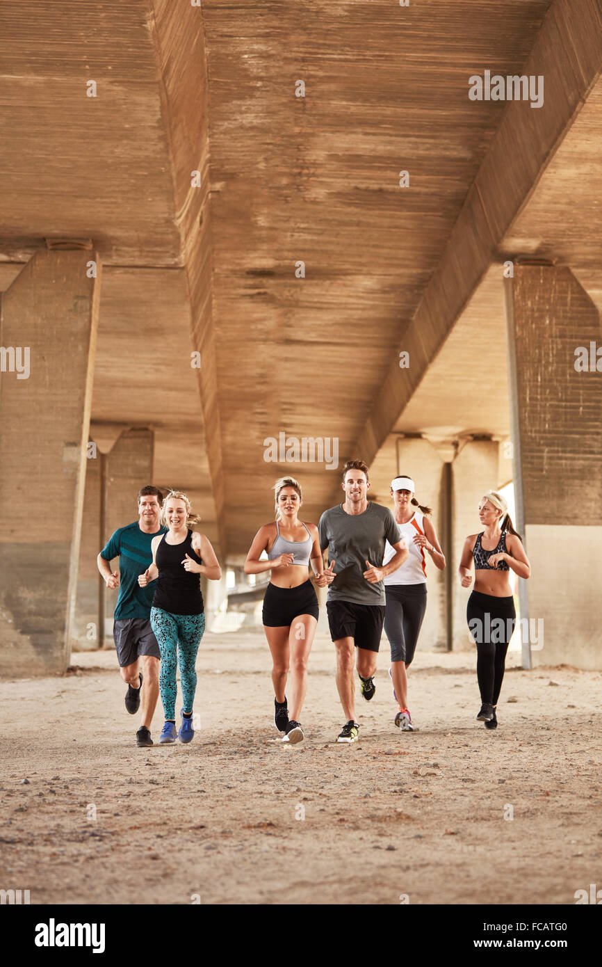 Porträt der gesunde junge Menschen, die unter einer Brücke. Club-Gruppe tragen Kleidung Schulung Sport in der Stadt laufen. Stockfoto