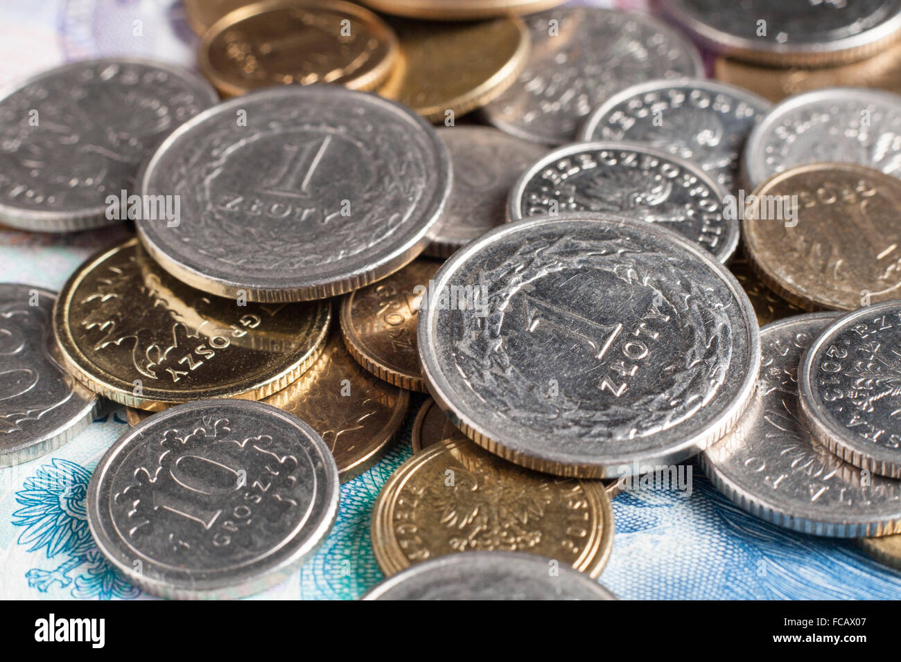 Zwei ein Złoty-Münzen auf weitere polnische Münzen und Scheine Stockfoto