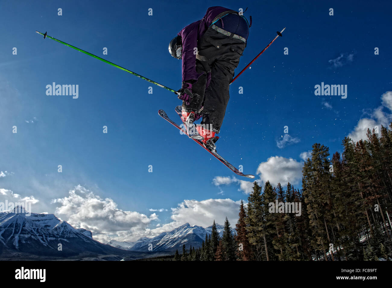 Ein Skifahrer fliegt hoch über der Piste im Skigebiet Lake Louise, Kanada Stockfoto