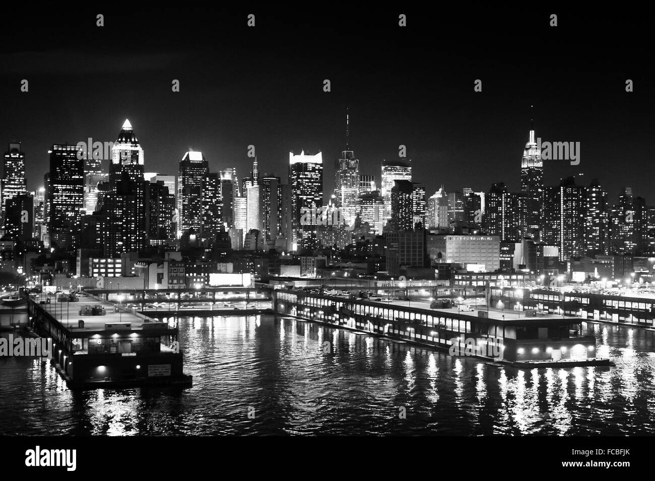 Das Panorama von Midtown Manhattan Küste mit Schiffen Pier vom Hudson River in der Nacht in New York City, USA gesehen. Stockfoto