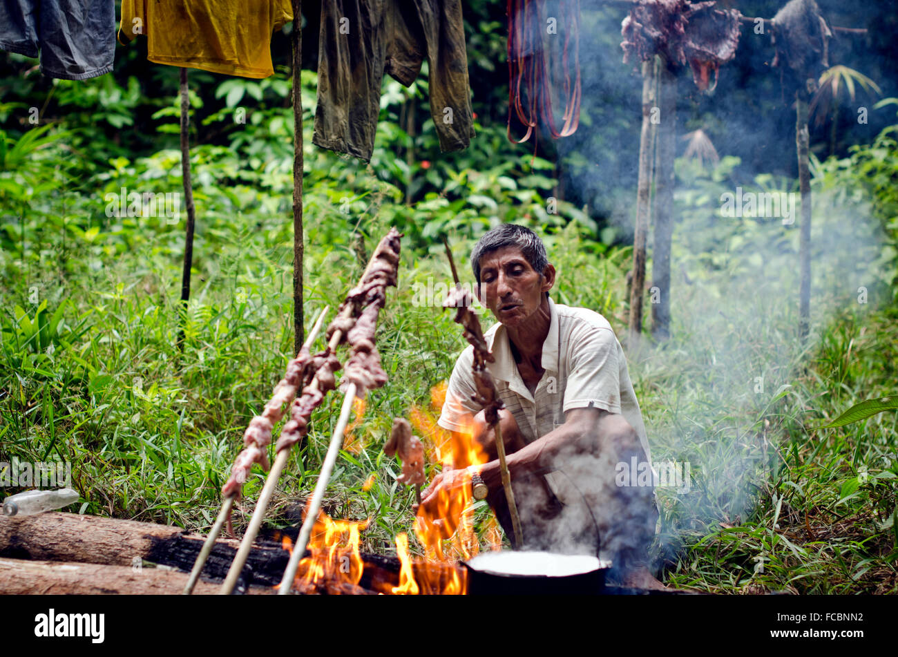 Schamanen und Jäger don Joel im Amazonas-Regenwald Braten Wildfleisch, Iquitos, Peru Stockfoto