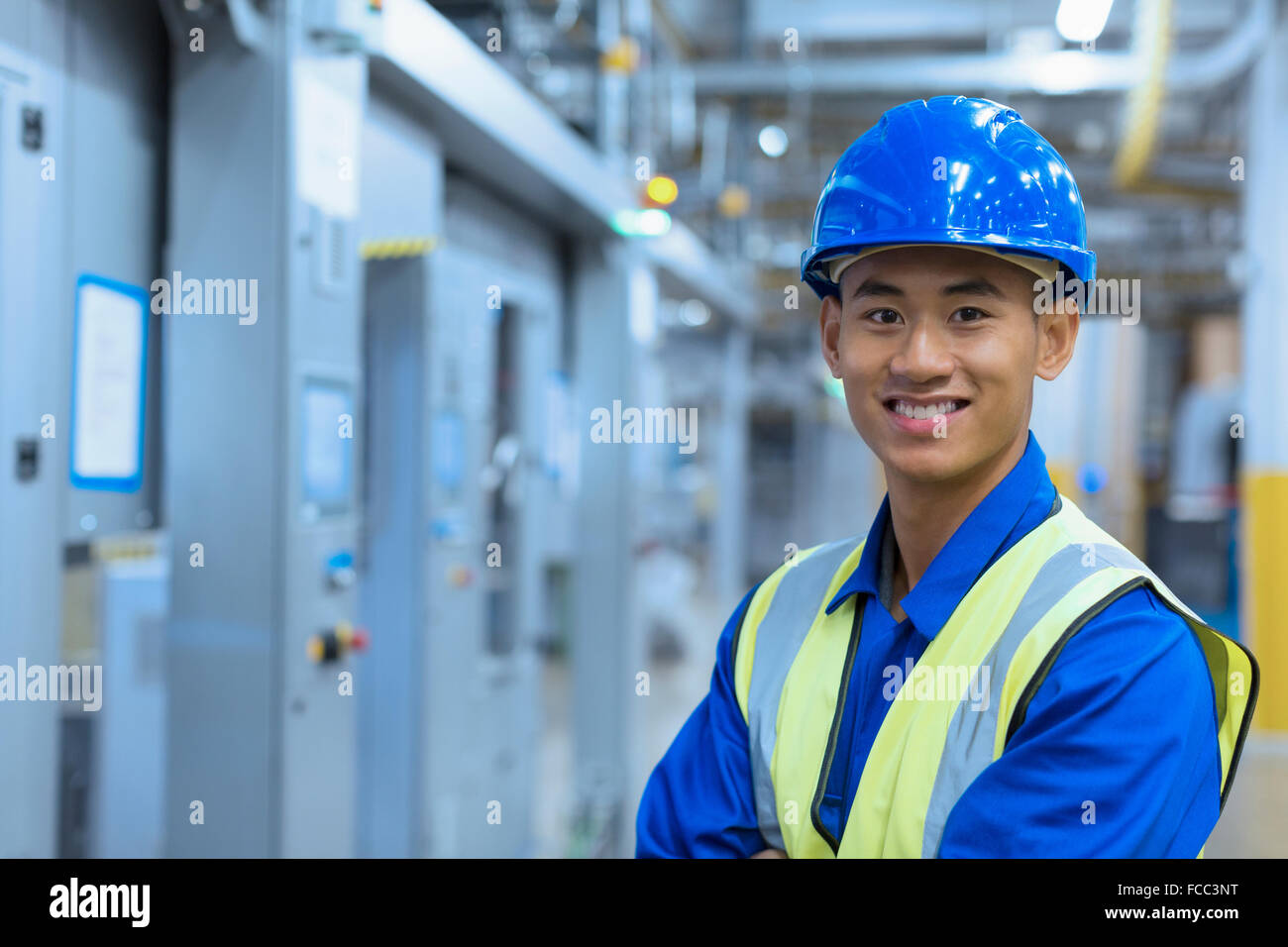 Porträt lächelnde Arbeiter in Akkubohrschrauber in Fabrik Stockfoto