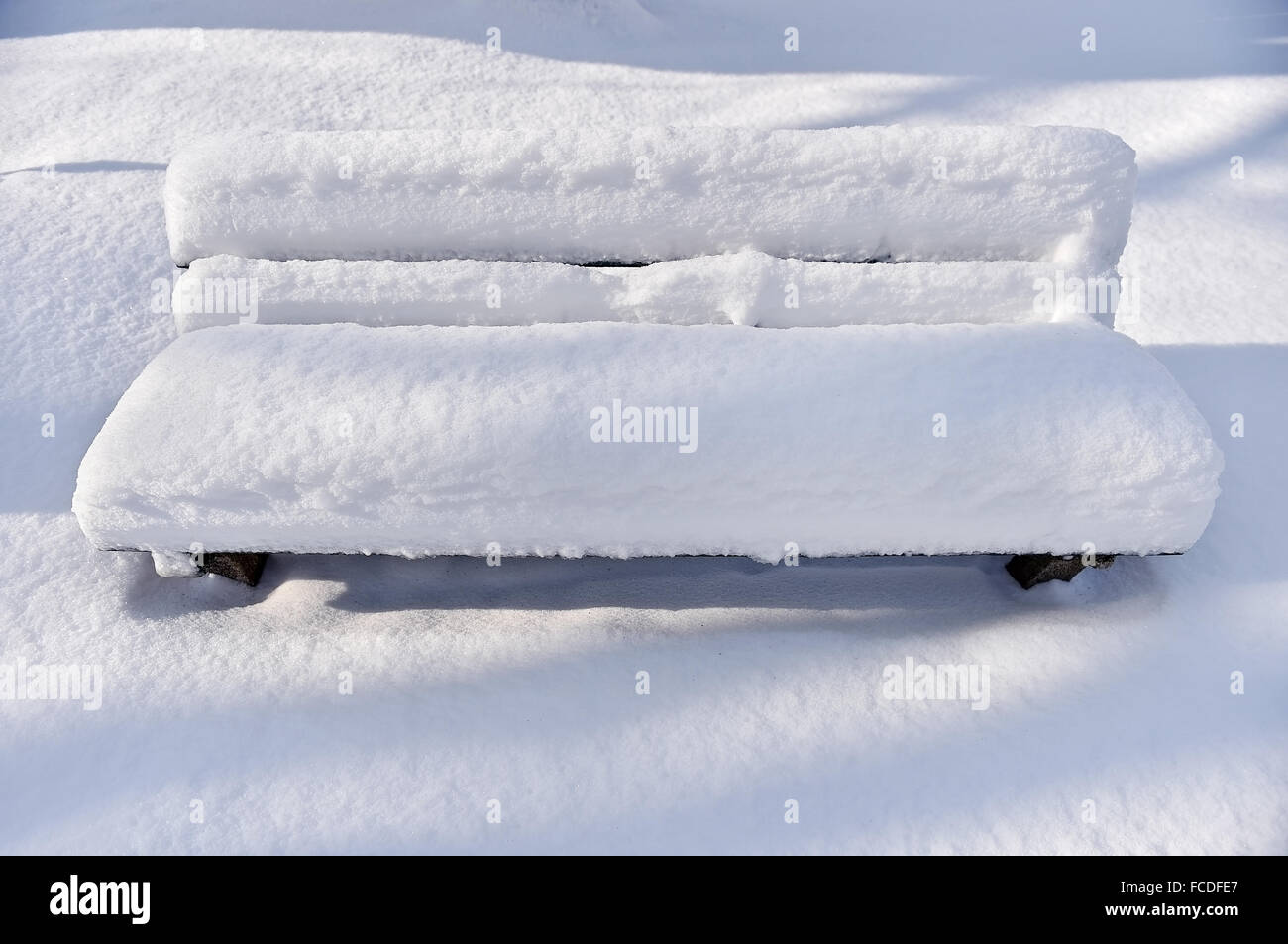 Parkbank komplett mit Schnee bedeckt, nach starkem Schneefall Stockfoto