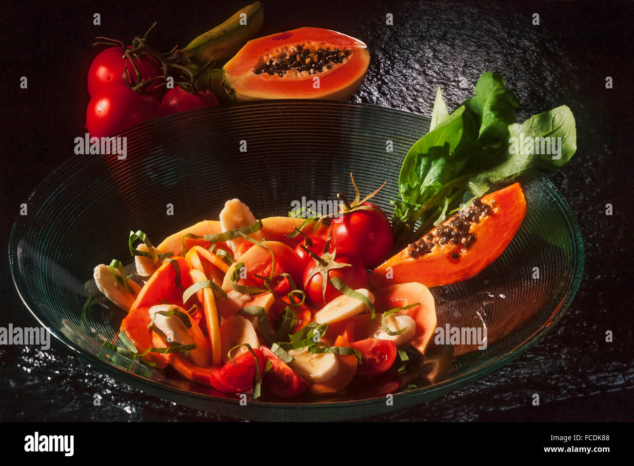 Salat, frisches Obst und Tomaten in Glasschale Stockfoto