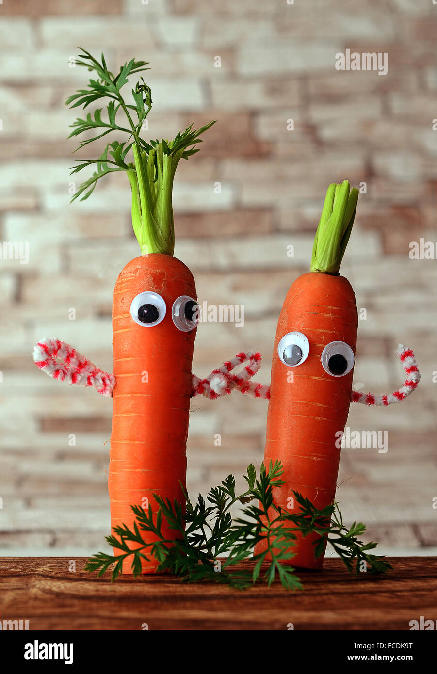 Zwei Karotten mit Gesichtern, symbolisches Bild für eine gesunde Ernährung Stockfoto