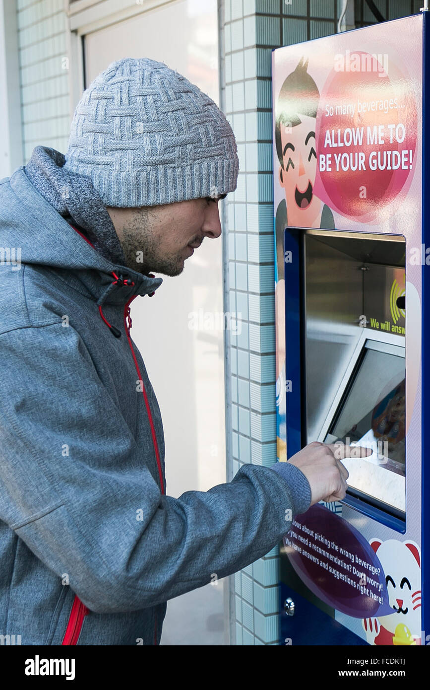 Tokio, Japan. 22. Januar 2016. Ein deutscher Tourist erhält Informationen über japanische Getränke aus einer interaktiven Automaten im Bezirk Asakusa am 22. Januar 2016, Tokio, Japan. Automaten sind beliebt in ganz Japan, aber viele verkaufen Getränke unbekannt, Besucher aus dem Ausland. Als Japan versucht, mehr Touristen in den Build bis zu den Olympischen Spielen in Tokio im Jahr 2020, einrichten Asahi Group Holdings in Zusammenarbeit mit Nomura Research Institute seine ersten interaktiven Automaten für englische Muttersprachler in der Nähe der Sensoji-Tempel in Asakusa. Bildnachweis: Aflo Co. Ltd./Alamy Live-Nachrichten Stockfoto