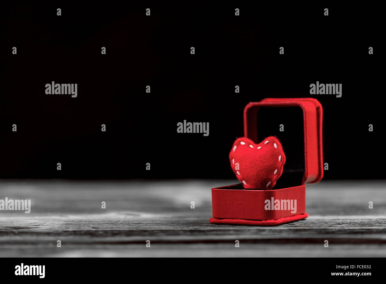 Roten Filz Herz in Ring Box auf hölzernen Hintergrund Stockfoto