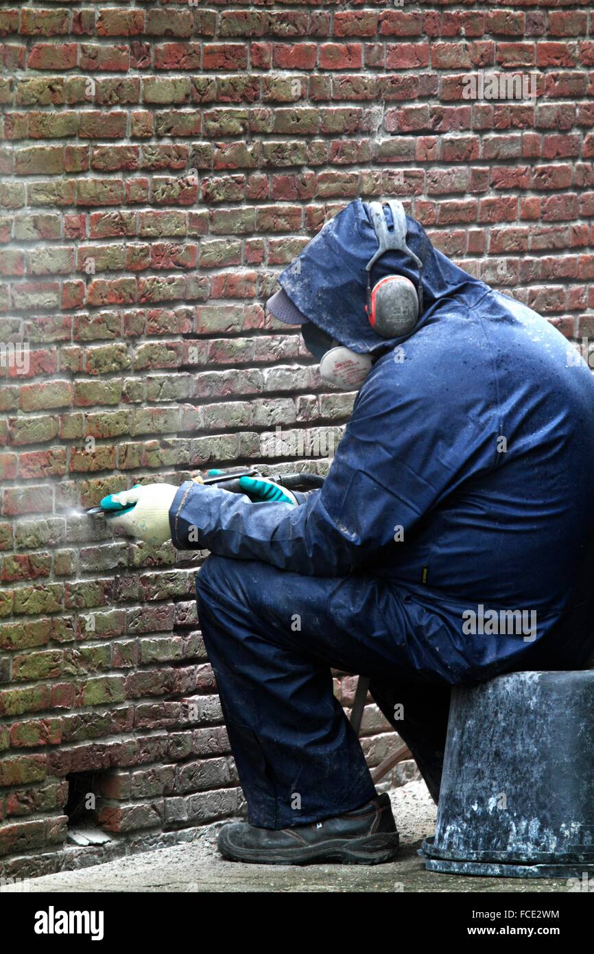 Niederlande, Mann bei der Arbeit auf Ziegelmauer Stockfoto