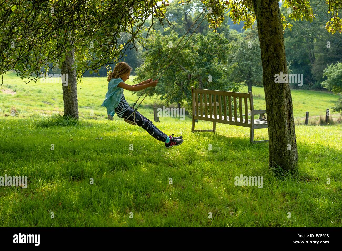 Frankreich, Normandie, kleines Mädchen auf einer Schaukel im Garten eine schöne Landschaft zu genießen Stockfoto