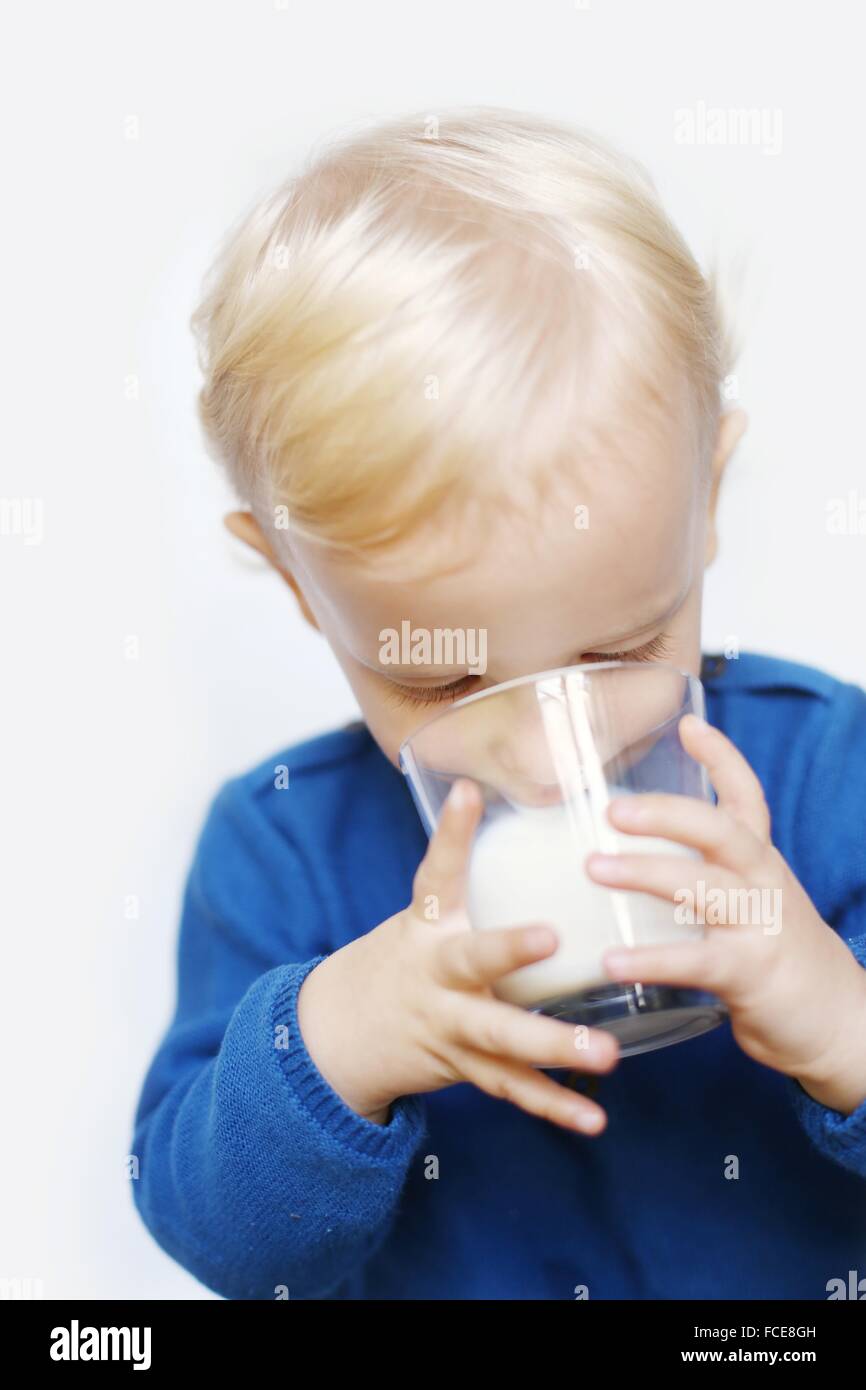 2 Jahre alter Junge, ein Glas Milch trinken Stockfoto