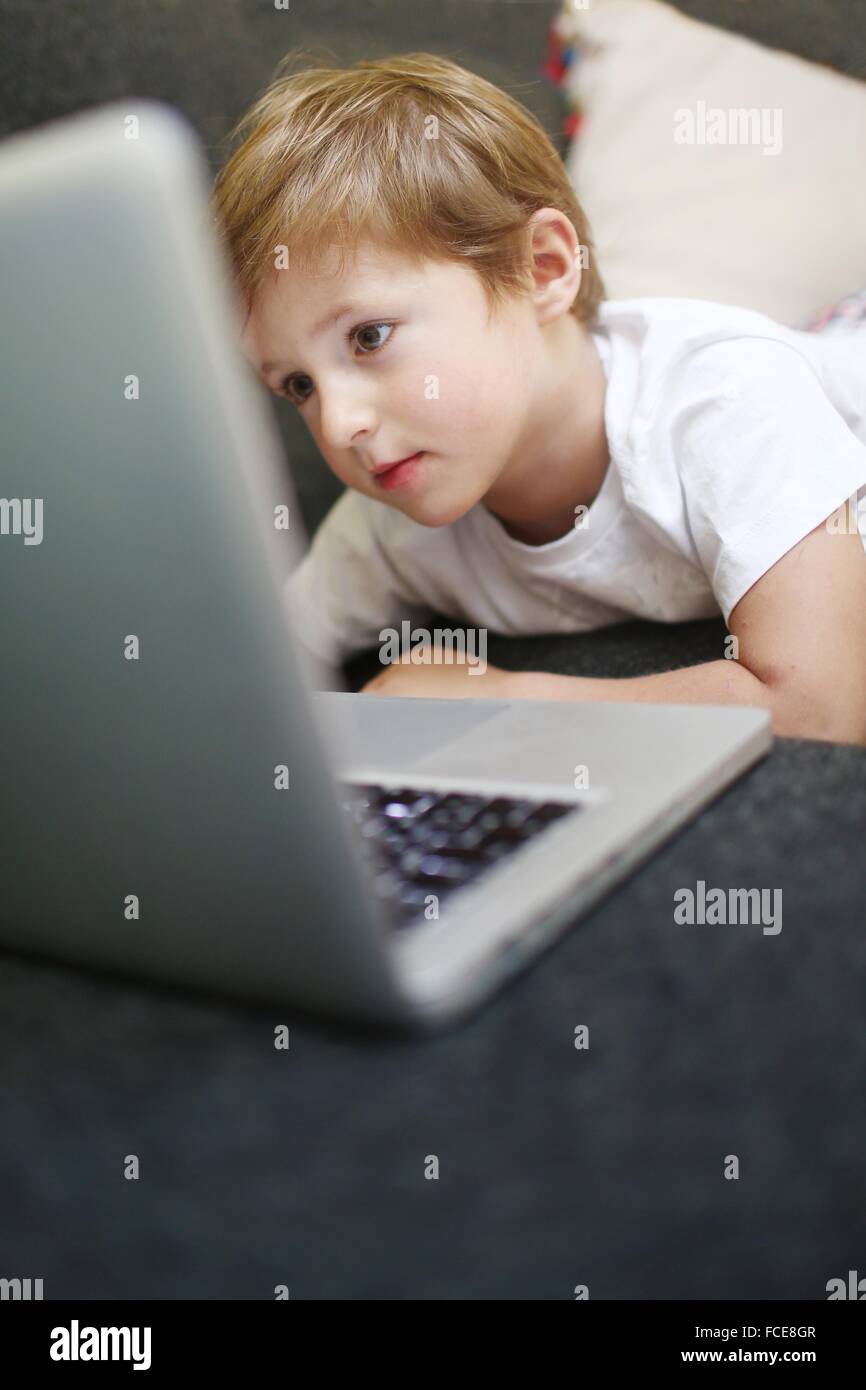 5 Jahre alter Junge Blick auf einem computer Stockfoto