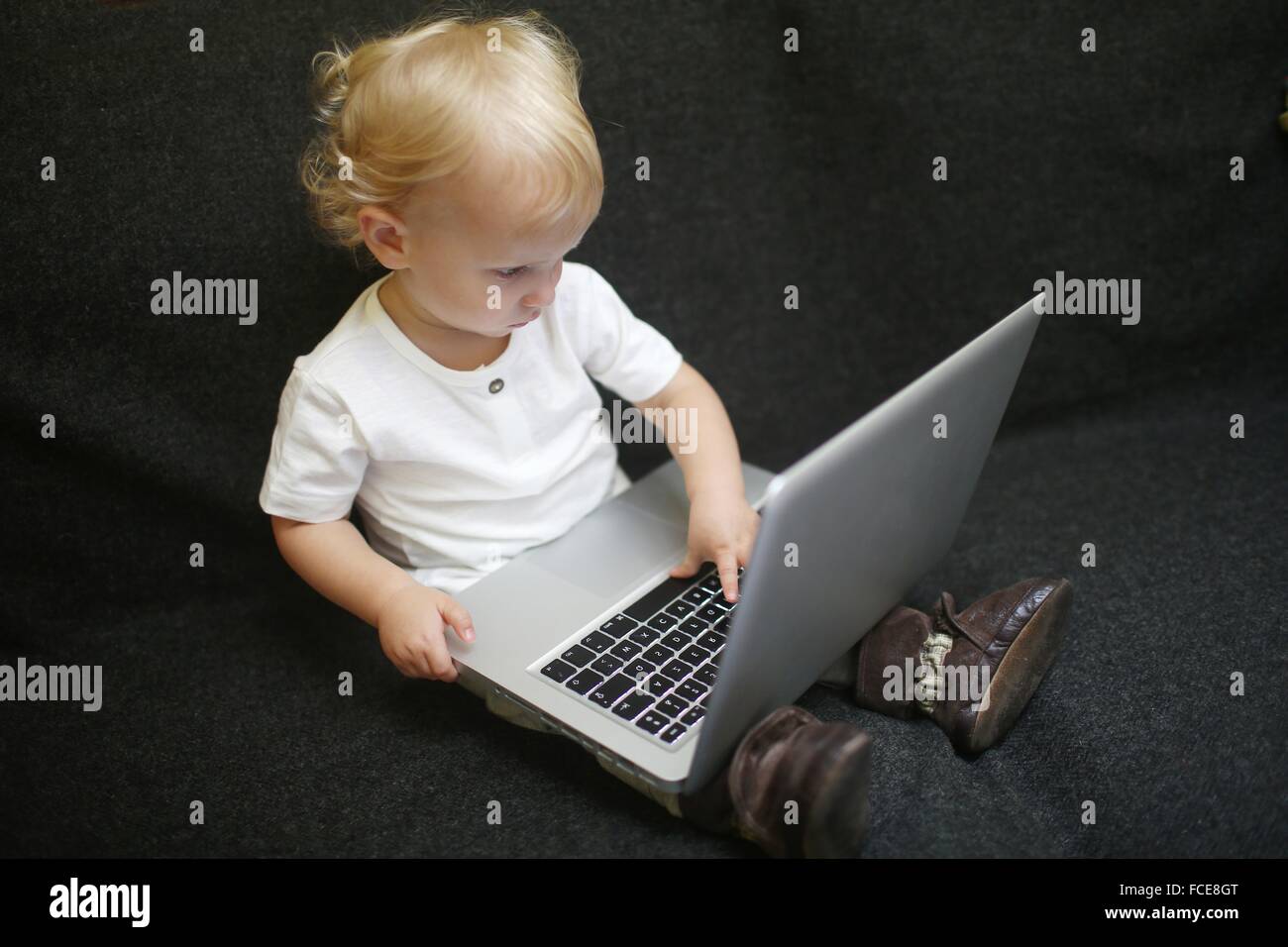 2 Jahre alter Junge mit einem Computer zu spielen Stockfoto