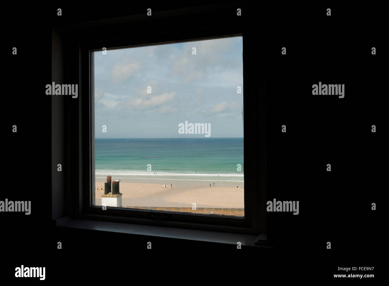 Blick auf Portmeor Strand, St Ives Form der Tate Gallery mit Schornstein im Vordergrund und Menschen am Strand im Hintergrund Stockfoto