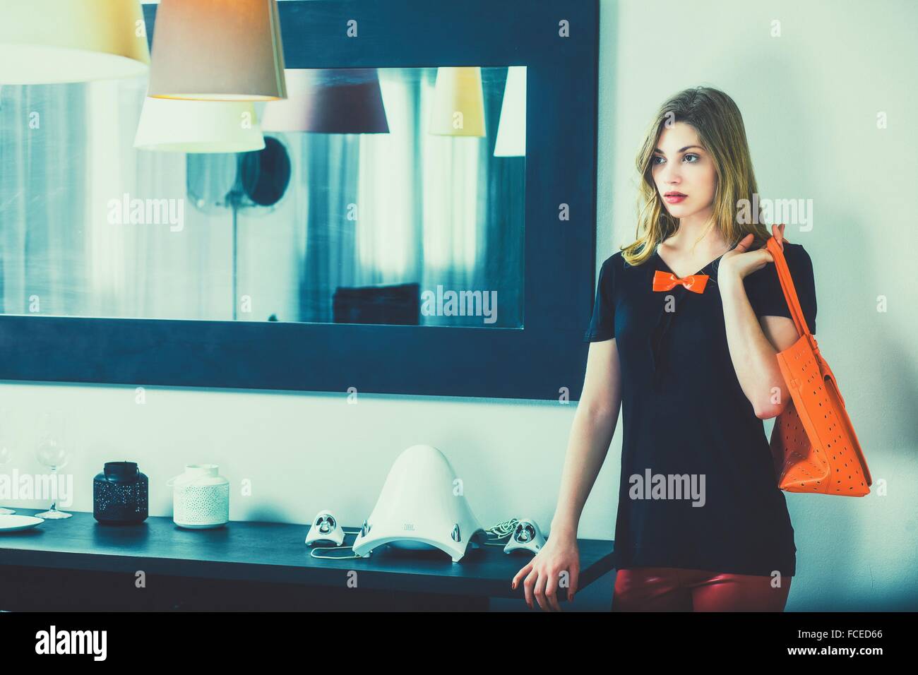 Junge Frau Stand halten ihre Handtasche Stockfoto