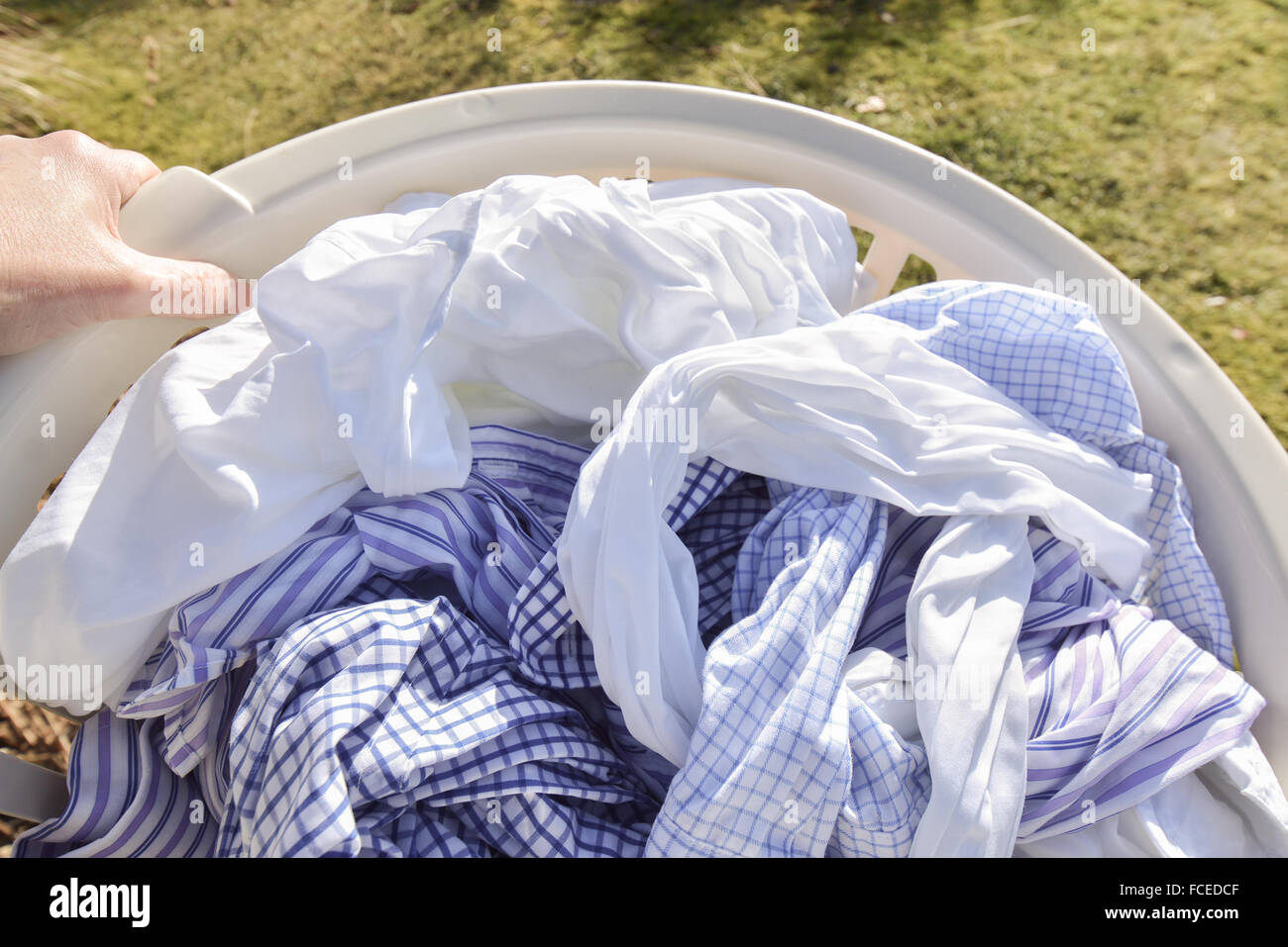 Korb voll mit weißen und blauen saubere Wäsche draußen aufgehängt werden, an der frischen Luft trocknen waschen Stockfoto