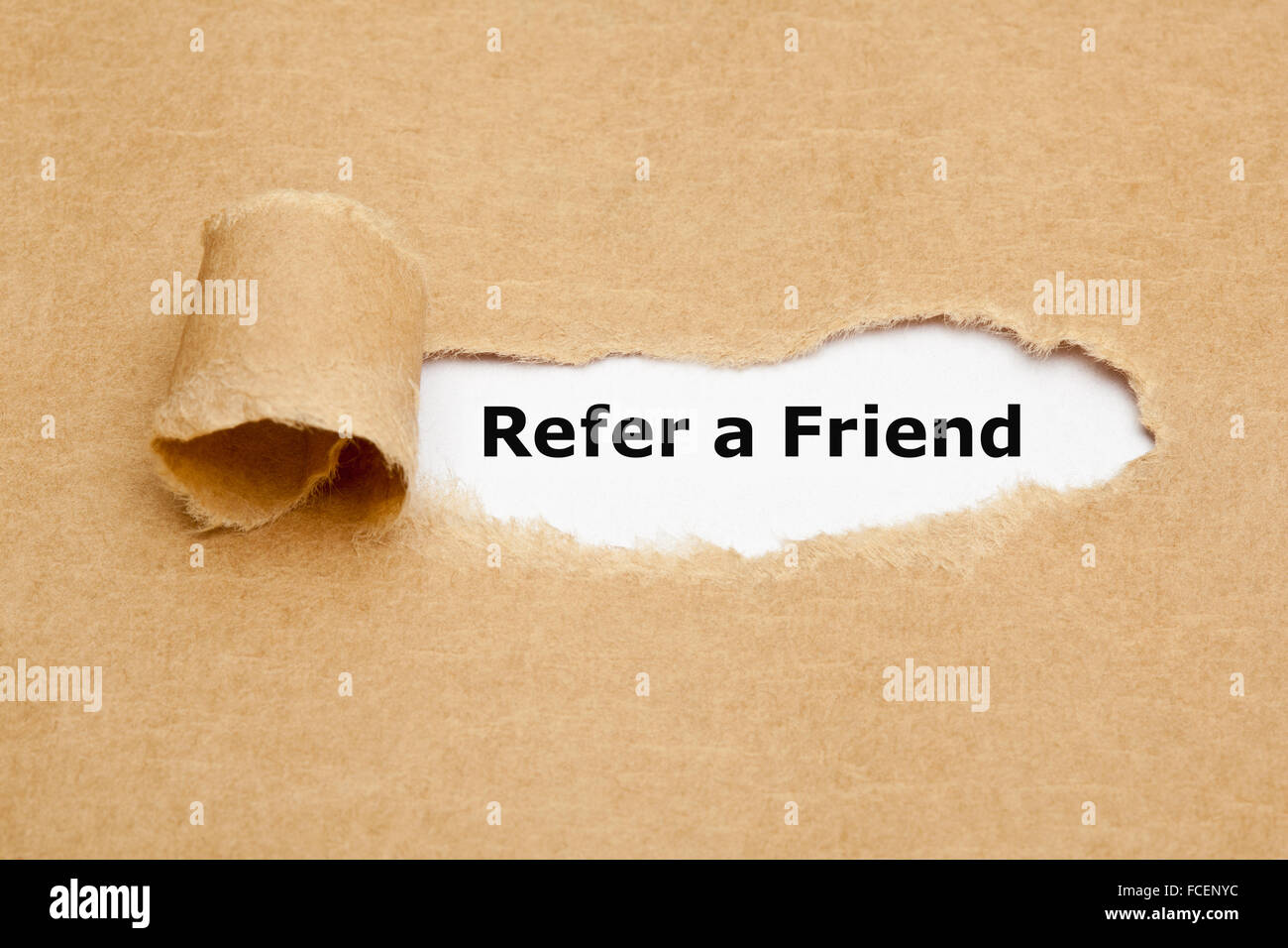 Der Text Refer a Friend erscheint hinter zerrissenes braunen Papier. Empfehlungs-marketing-Konzept. Stockfoto