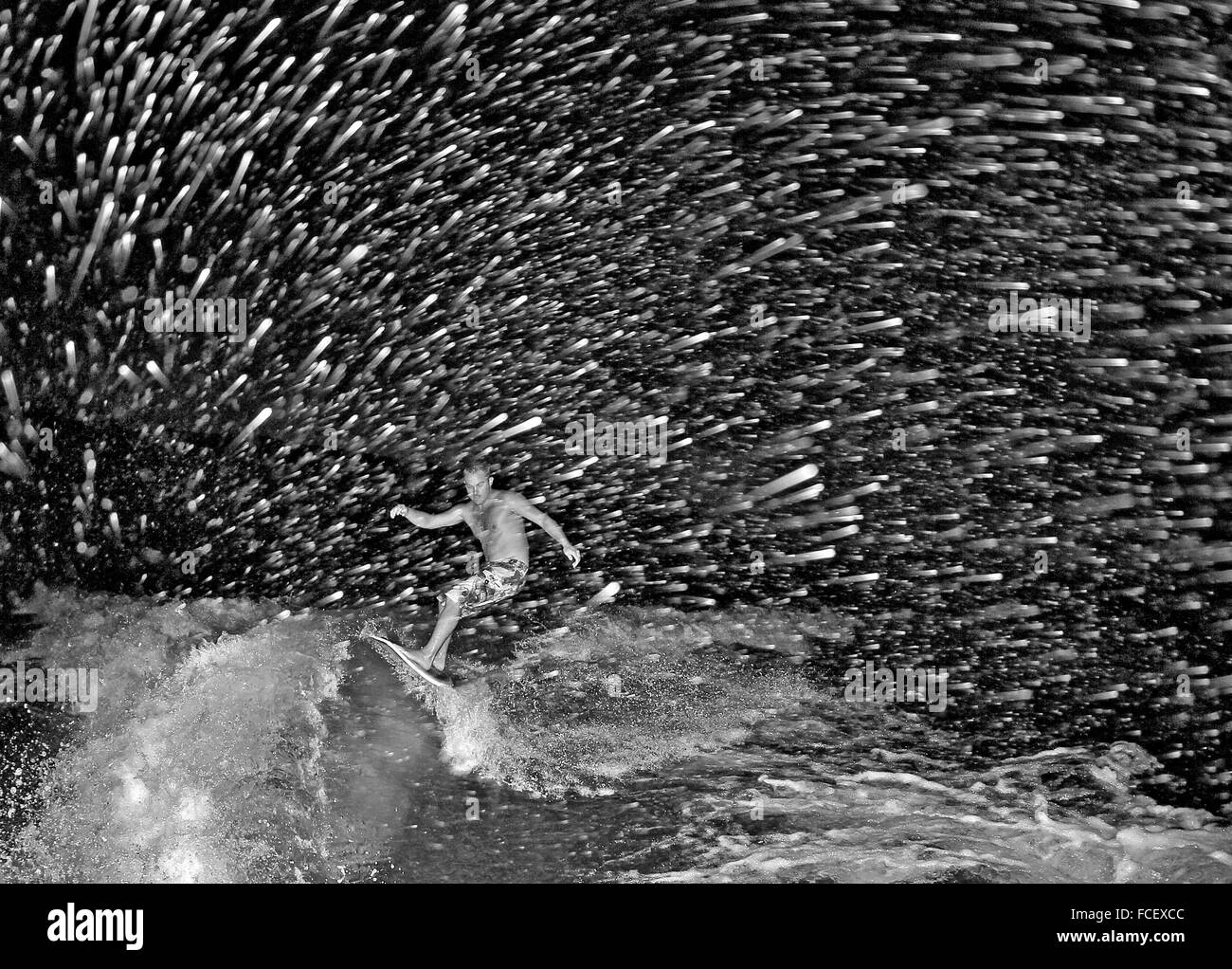 Mann-Surfen im Meer in der Nacht Stockfoto