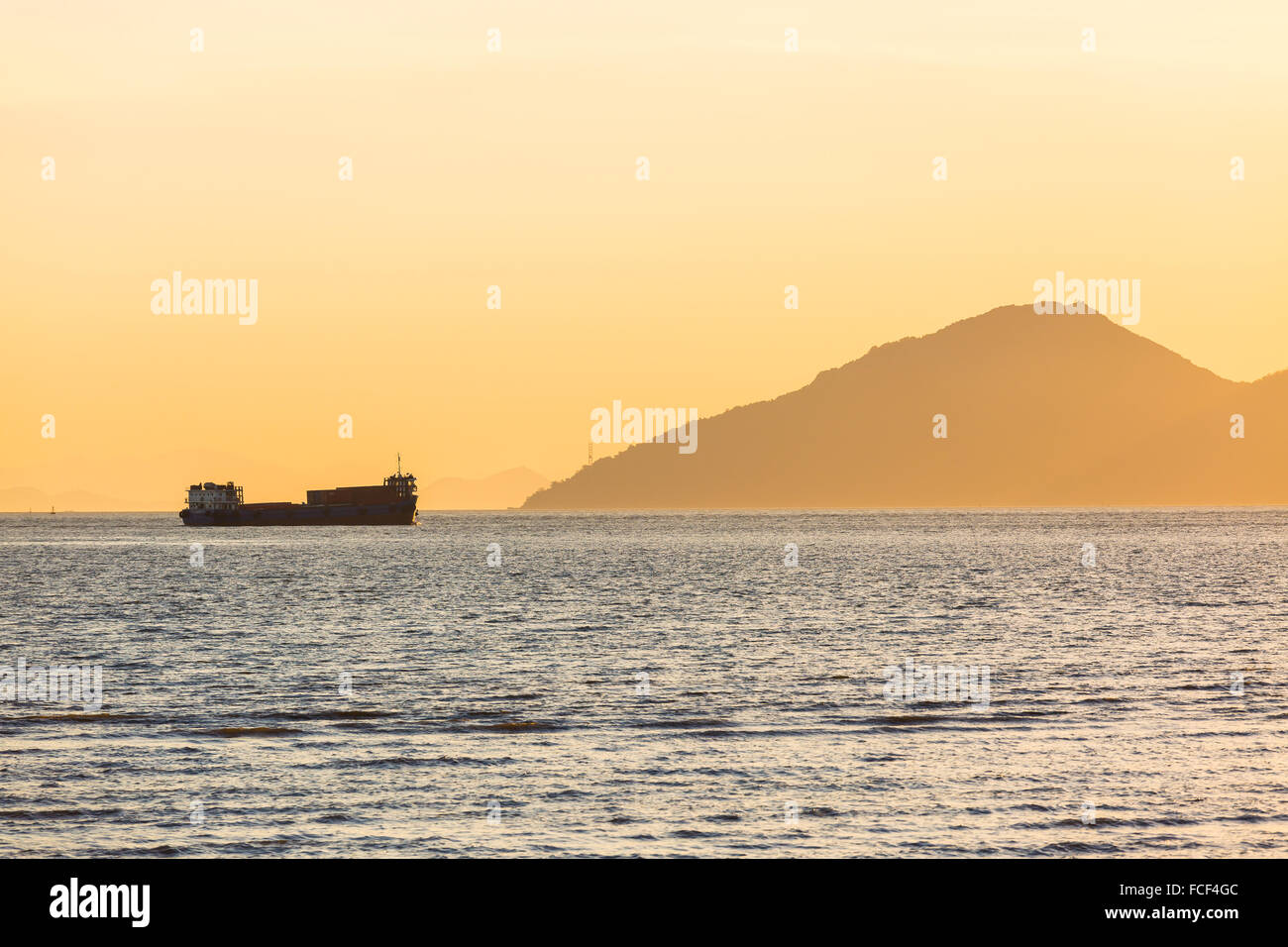Frachtschiff bei Sonnenuntergang segeln Stockfoto
