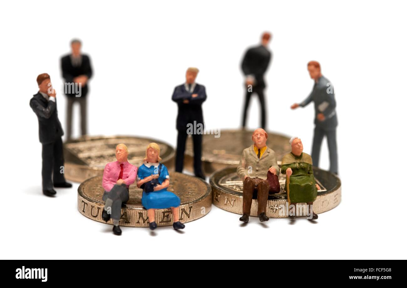 2 Miniatur-Paare sitzen auf britischen Münzen umgeben von Finanzberater in Anzügen Konzept. Stockfoto