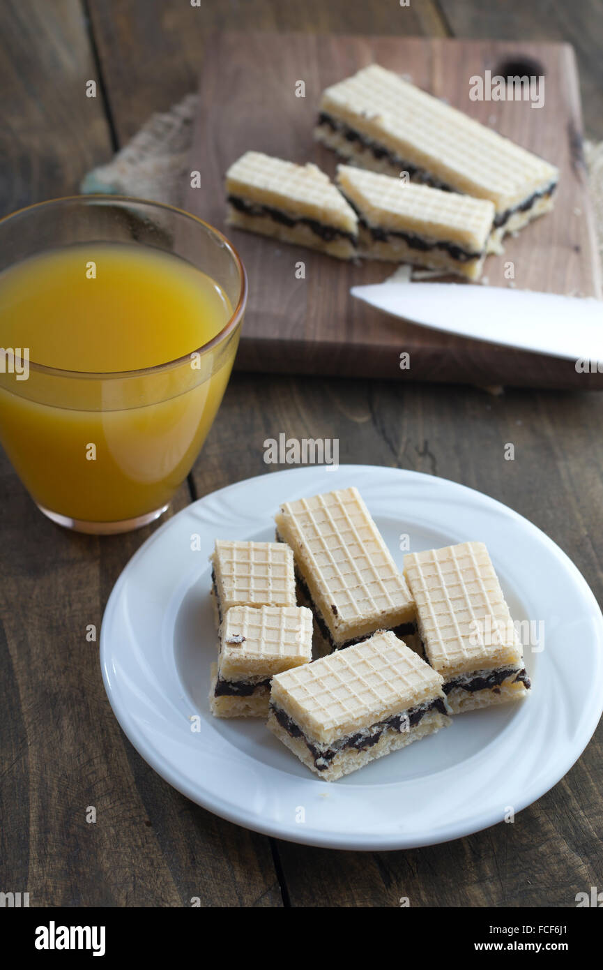 Waffel-Kuchen mit Schokolade und Saft auf Tisch Stockfoto