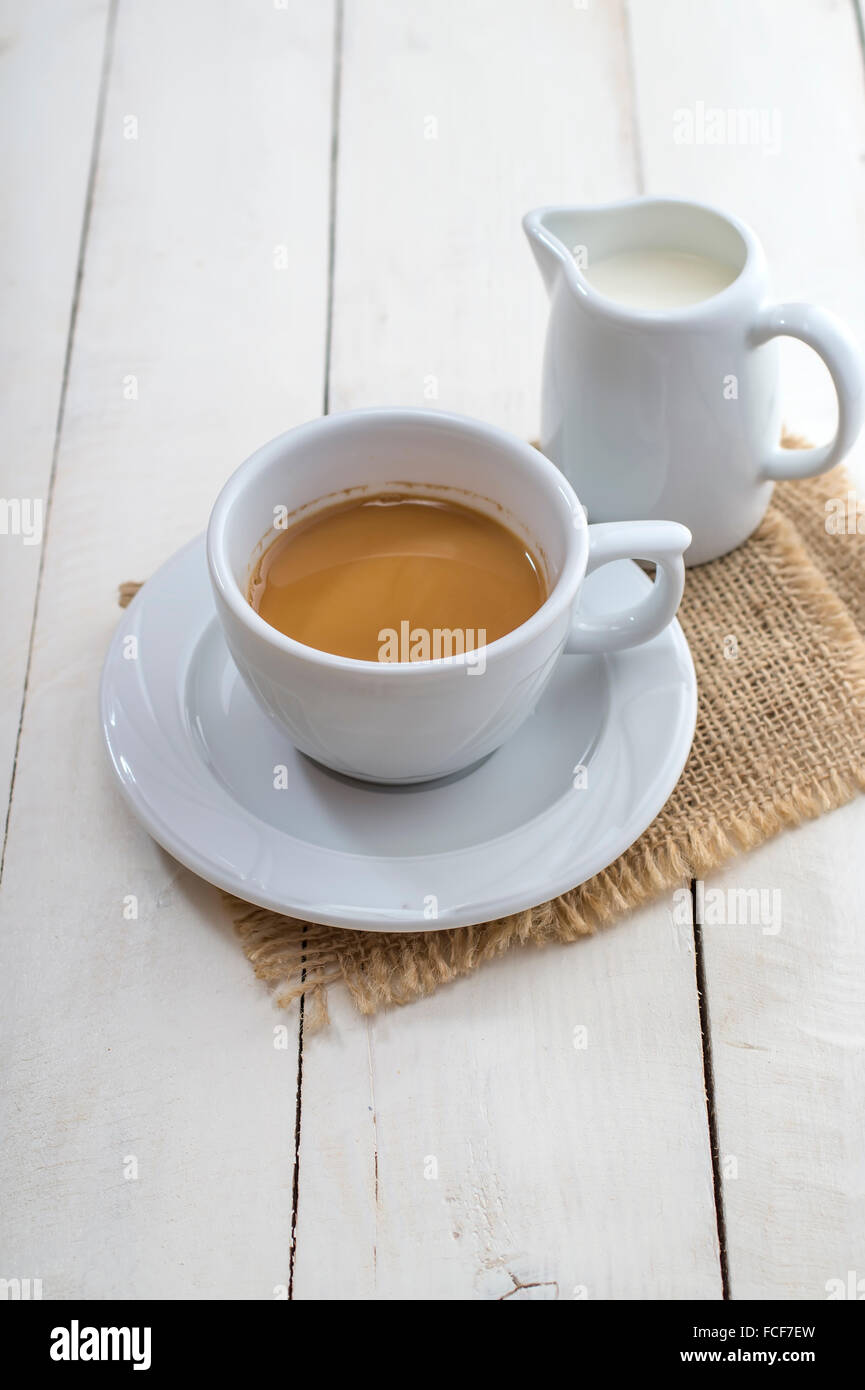 Tasse Kaffee und Milch auf weißer Holztisch Stockfoto