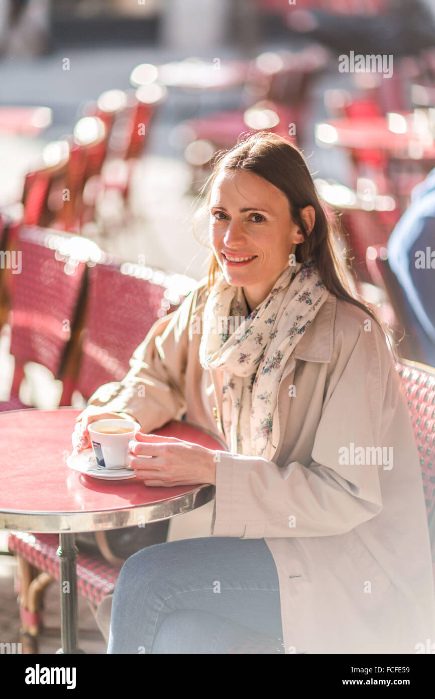 Frau trinkt Kaffee am Café Terrasse. Stockfoto