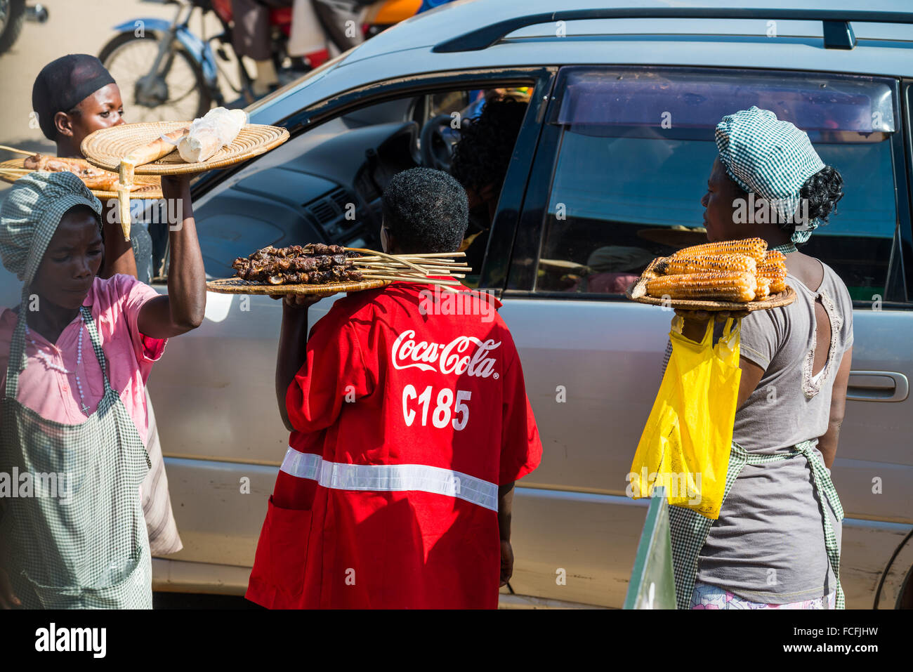 Straßenverkäufer verkaufen waren Menschen in den lokalen Bussen vorbei durch die Dörfer auf dem Weg heraus aus Kampala, Uganda, Afrika Stockfoto