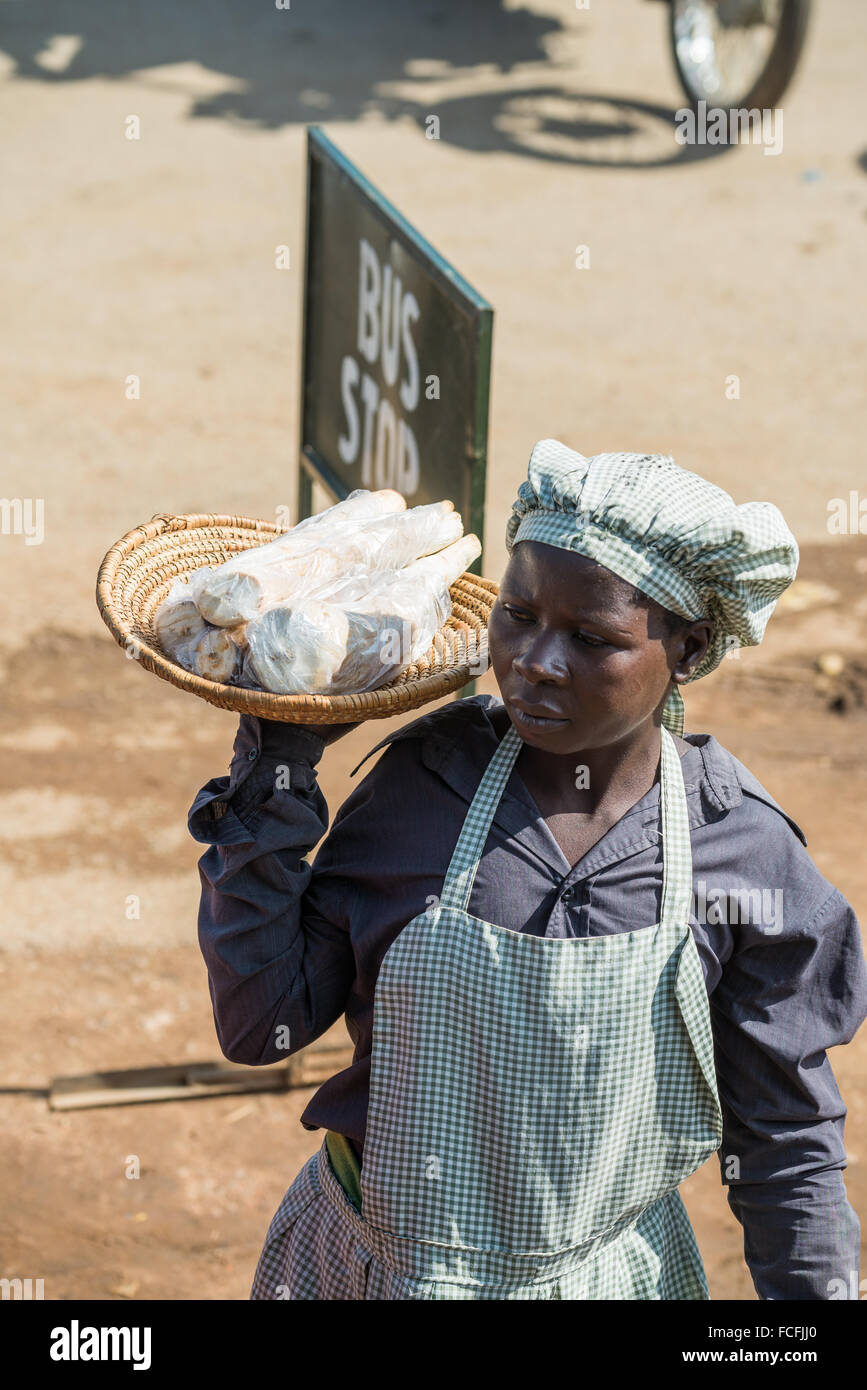 Straßenverkäufer verkaufen waren Menschen in den lokalen Bussen vorbei durch die Dörfer auf dem Weg heraus aus Kampala, Uganda, Afrika Stockfoto