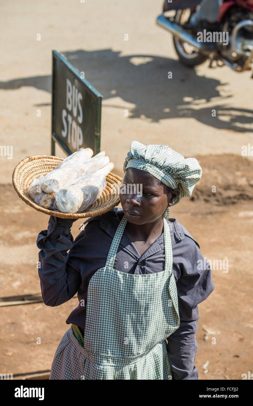 Straßenverkäufer verkaufen waren Menschen in den lokalen Bussen vorbei durch die Dörfer auf dem Weg heraus aus Kampala, Uganda, Afrika Stockfoto
