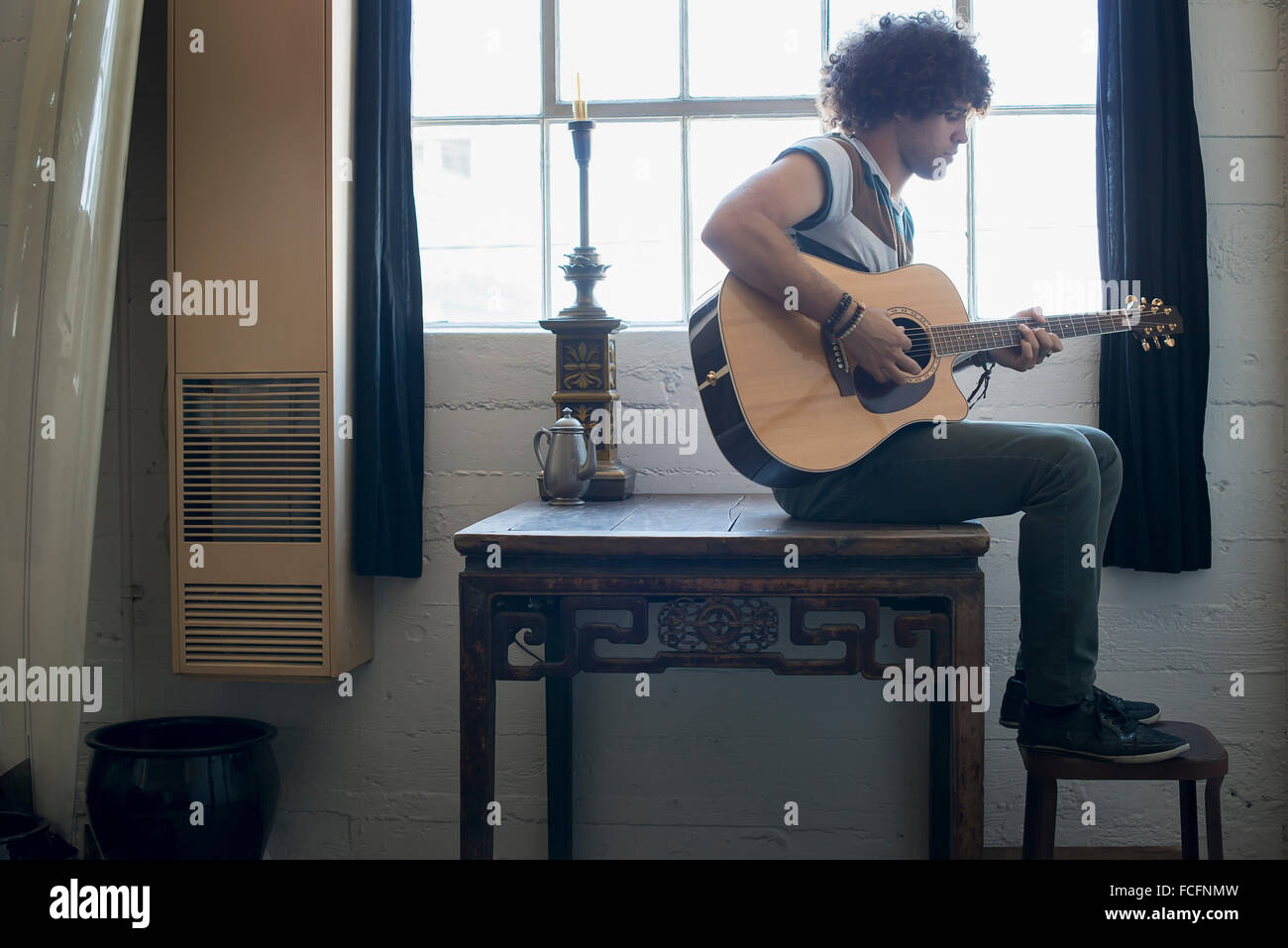Loft-lebendigen. Ein junger Mann Gitarre spielen. Stockfoto