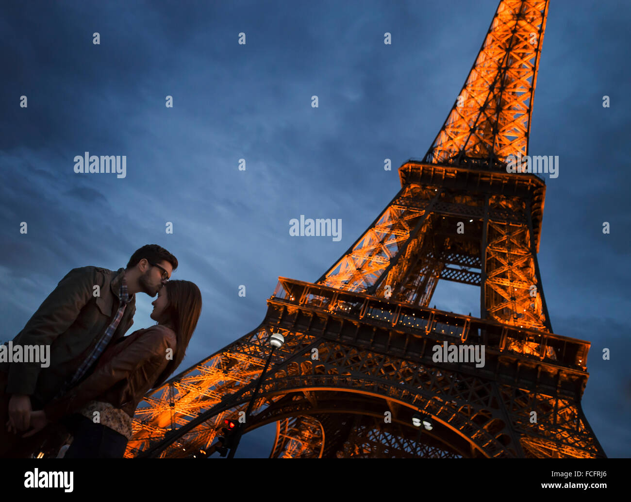 Ein paar stehen unter Lee auf den Eiffelturm in der Nacht in der Champs de Mars in Paris. Stockfoto