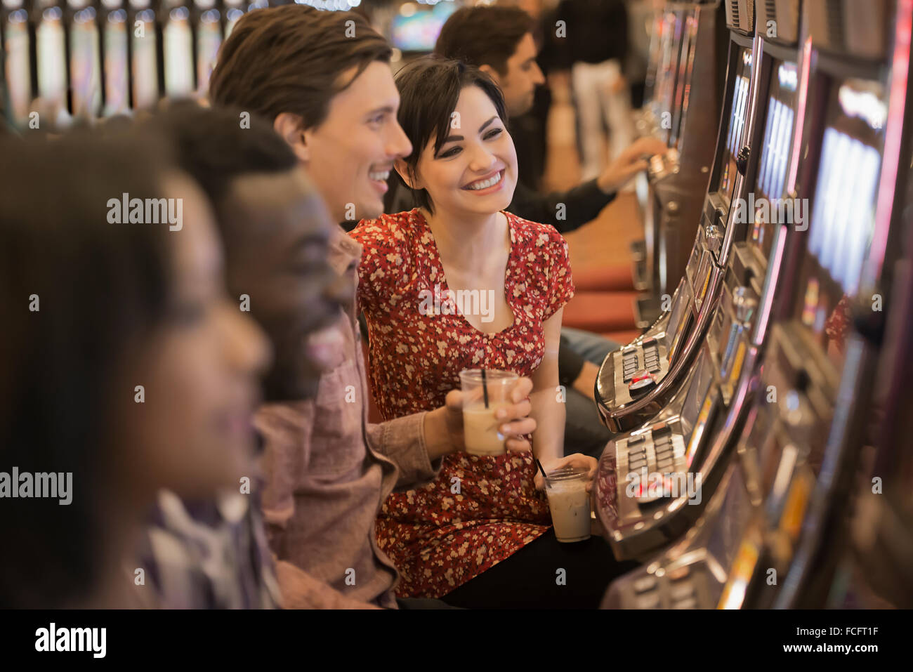 Eine Gruppe von Menschen, die die Spielautomaten im Casino spielen. Stockfoto