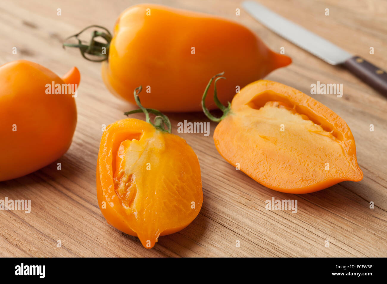 Ganze und halbe frische orange Paprika-Tomaten Stockfoto