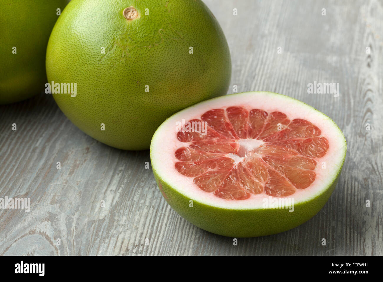 Frische rote ganze und halbe Pomelo Frucht Stockfoto